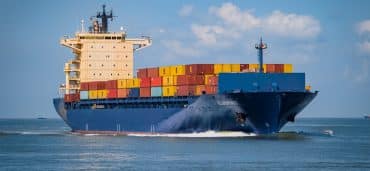 image of shipping containers on the back of a ship for blog How Shipping Companies Deliver Success: What To Look For